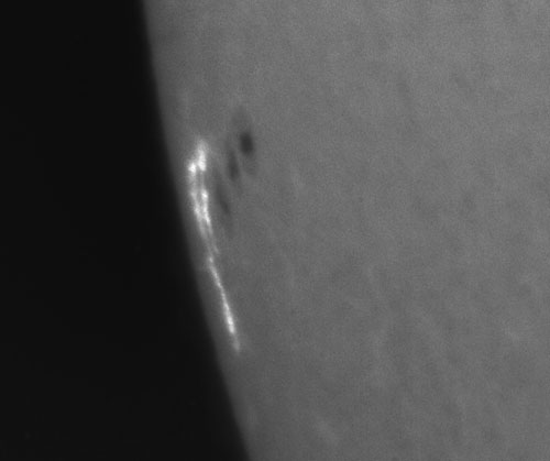 Detailní snímek aktivní oblasti NOAA 12087 v čáře vodíku ze dne 10. 6. 2014 pořízený dne 12:46:32 UT. Jsou velmi dobře patrná intenzivní zjasnění v erupčních kanálech.