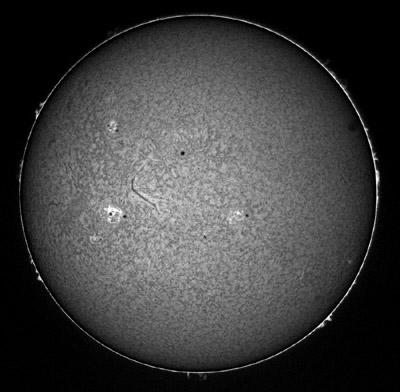 Snímek celého disku Slunce v čáře H-alpha, tzn. snímek pořízený s filtrem, který propouští světlo o vlnové délce na 656 nm. Na snímku si můžete všimout jak slunečních skvrn, tak i protuberancí (na okraji disku), výrazného filamentu (zhruba uprostřed snímku) a erupce (v aktivní skupině nalevo od filamentu).  