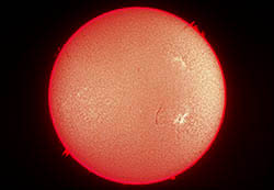 Snímek sluneční chromosféry včetně viditelných protuberancí na okraji slunečního disku.